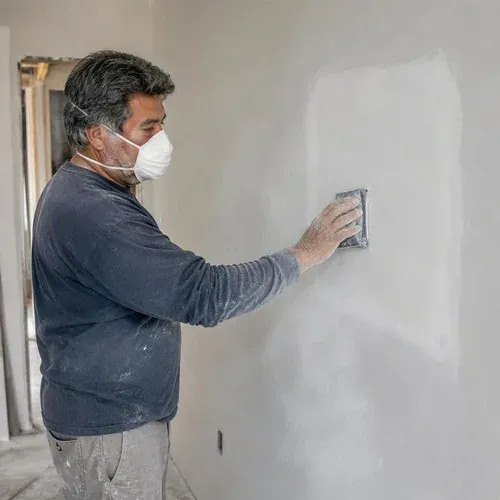 Sanding a drywall patch flat and feathering the edges out into the surrounding wall