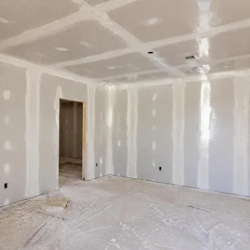 Drywall seams and screw heads coated with wet compound, left to dry a full day between coats