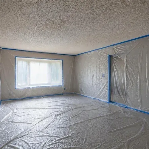 Plastic sheeting masking floors and walls before any popcorn ceiling texture comes down