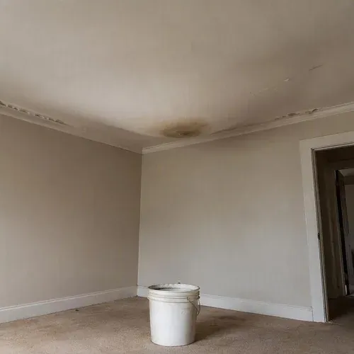 Sagging wet drywall bulging below a roof leak, past saving and ready to come out